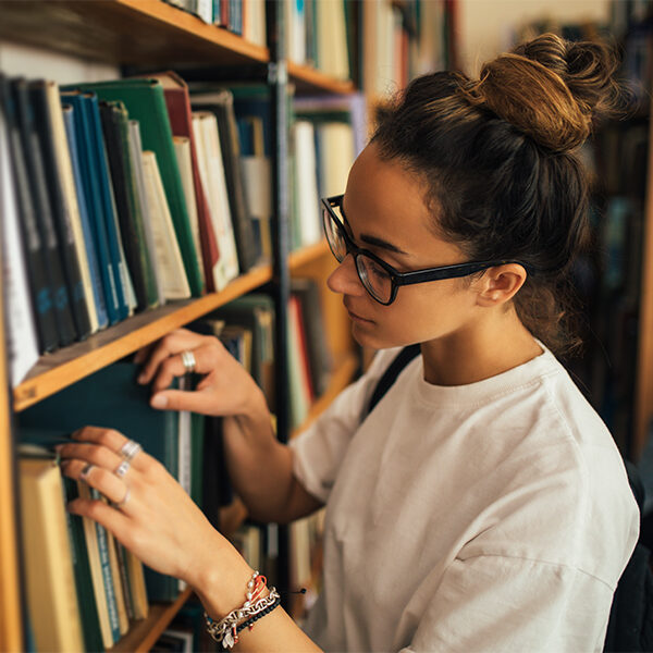 A student stuying and reading books in a public library of university.